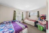 Home and income on 801m2 section, two separate three-bedroom dwellings on one title, each with its own driveway, currently rented for $1,030 per week, close to schools, golf club, shops, 18 Volante Avenue, Wattle Downs, Auckland