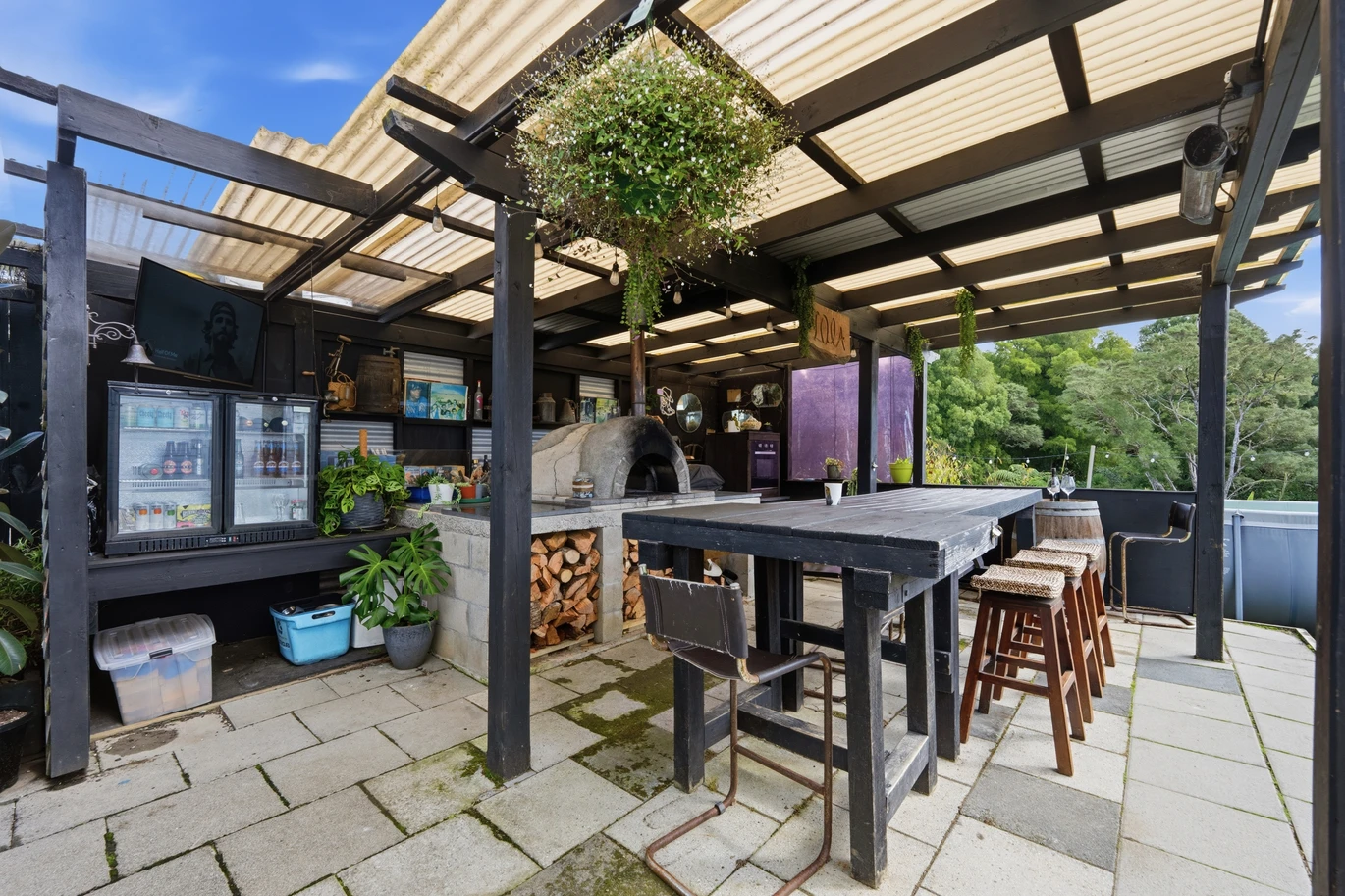 909m2 section, 158m2 4 beds 2 baths main houe PLUS a separate wing/sleepout with a 5th bedroom, bathroom, and covered deck, a massive covered patio with a professional-grade wood-fired pizza oven and a fully equipped outdoor bar area, a large carport, close to reserves, local shops, schools, 23 Tabitha Crescent Henderson, Auckland