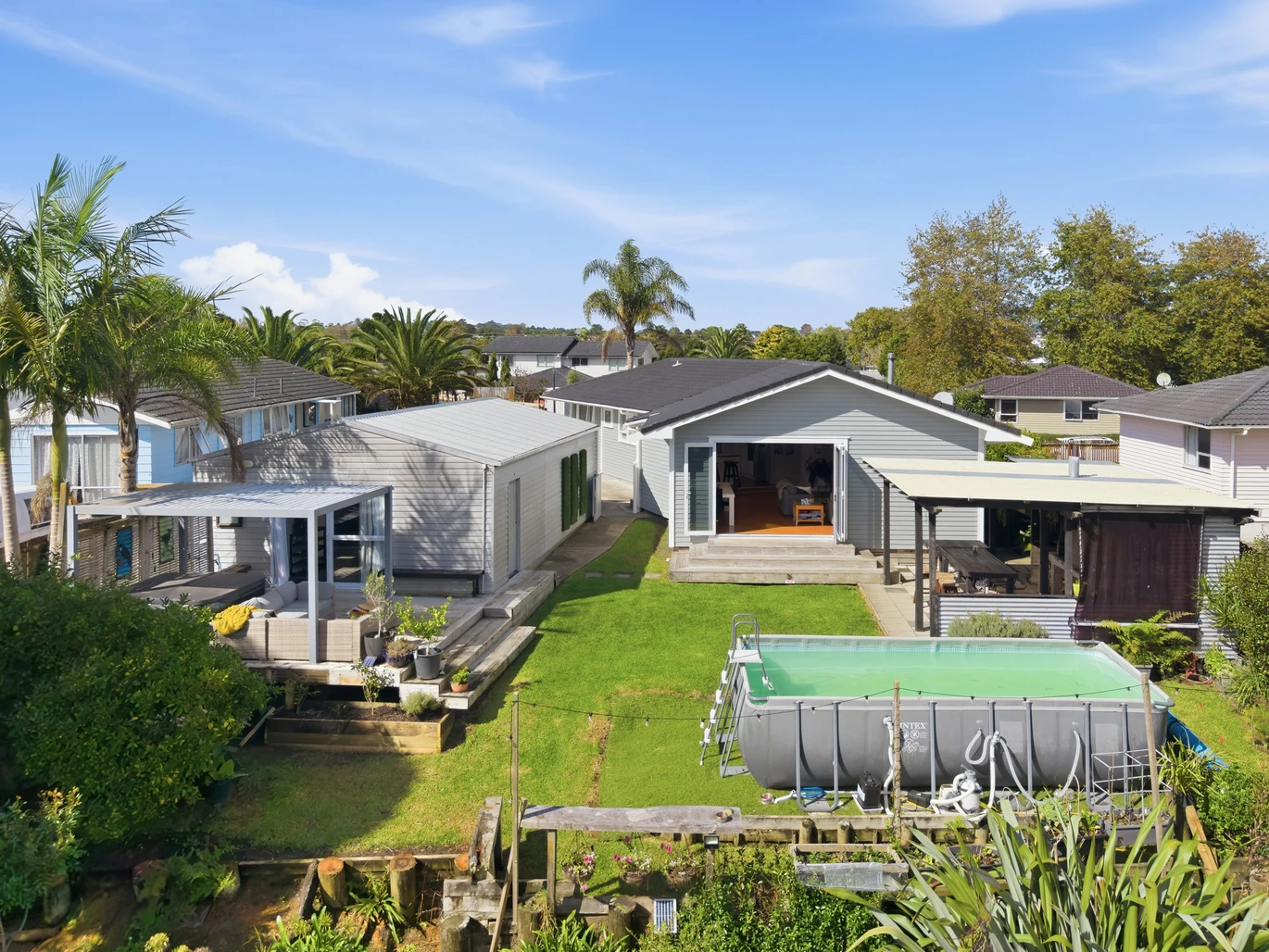 909m2 section, 158m2 4 beds 2 baths main houe PLUS a separate wing/sleepout with a 5th bedroom, bathroom, and covered deck, a massive covered patio with a professional-grade wood-fired pizza oven and a fully equipped outdoor bar area, a large carport, close to reserves, local shops, schools, 23 Tabitha Crescent Henderson, Auckland
