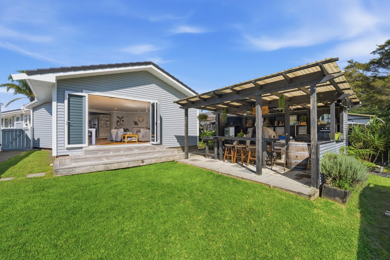 909m2 section, 158m2 4 beds 2 baths main houe PLUS a separate wing/sleepout with a 5th bedroom, bathroom, and covered deck, a massive covered patio with a professional-grade wood-fired pizza oven and a fully equipped outdoor bar area, a large carport, close to reserves, local shops, schools, 23 Tabitha Crescent Henderson, Auckland