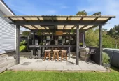 909m2 section, 158m2 4 beds 2 baths main houe PLUS a separate wing/sleepout with a 5th bedroom, bathroom, and covered deck, a massive covered patio with a professional-grade wood-fired pizza oven and a fully equipped outdoor bar area, a large carport, close to reserves, local shops, schools, 23 Tabitha Crescent Henderson, Auckland