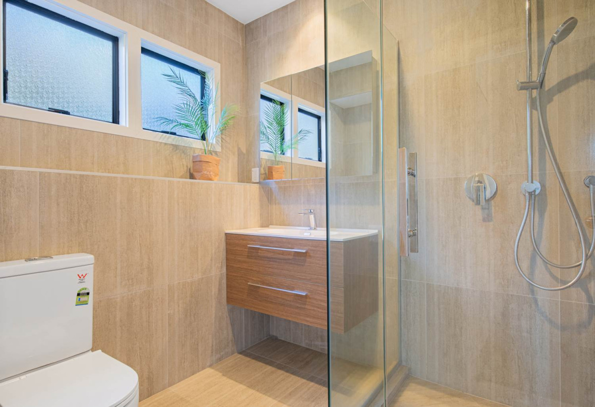 1030m2 section, Elegant Living, Sea Views & Rangitoto Zones, 6 beds (1 ensuite) + study 3.5 baths house with garage and swimming pool, A supersized entertaining lounge on the lower level, along with its own bathroom and two generous bedrooms, provides exceptional flexibility. 32 Bellbird Rise, Murrays Bay, Auckland