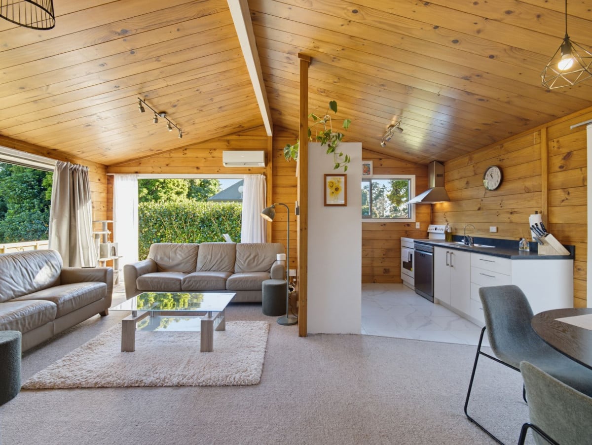 1088m2 section, 3 beds 1 bath house with carport, wooden walls and ceilings wrap around the interconnected lounge, dining area and kitchen. and Outside, the multi-level timber deck, 37A Youngs Road, Papakura, Auckland