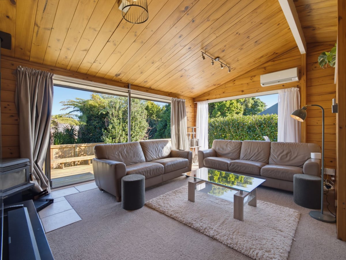 1088m2 section, 3 beds 1 bath house with carport, wooden walls and ceilings wrap around the interconnected lounge, dining area and kitchen. and Outside, the multi-level timber deck, 37A Youngs Road, Papakura, Auckland