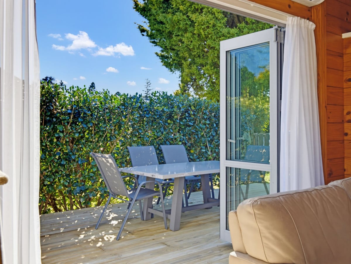 1088m2 section, 3 beds 1 bath house with carport, wooden walls and ceilings wrap around the interconnected lounge, dining area and kitchen. and Outside, the multi-level timber deck, 37A Youngs Road, Papakura, Auckland