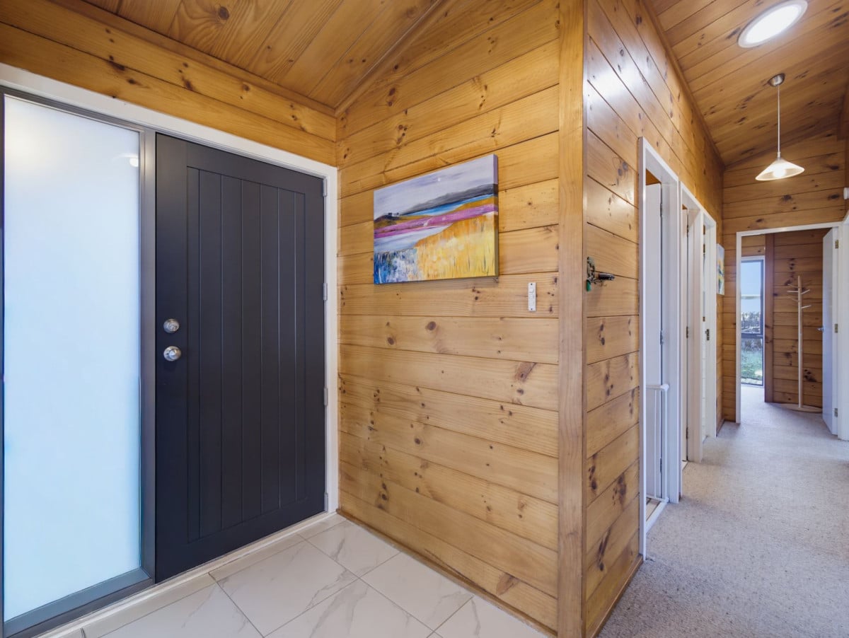 1088m2 section, 3 beds 1 bath house with carport, wooden walls and ceilings wrap around the interconnected lounge, dining area and kitchen. and Outside, the multi-level timber deck, 37A Youngs Road, Papakura, Auckland