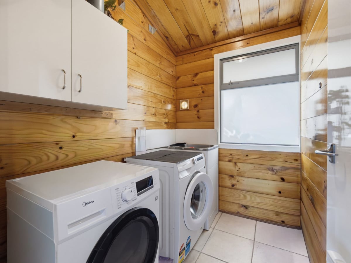 1088m2 section, 3 beds 1 bath house with carport, wooden walls and ceilings wrap around the interconnected lounge, dining area and kitchen. and Outside, the multi-level timber deck, 37A Youngs Road, Papakura, Auckland
