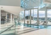 Just 160 metres from Waiake Beach, 1948m2 section, Built-in lift, 5 beds (5 ensuites) + office and wine room 6.5 baths house with 4 garage and the 18-metre cantilevered lap pool, 4 Sharon Road, Waiake, Auckland