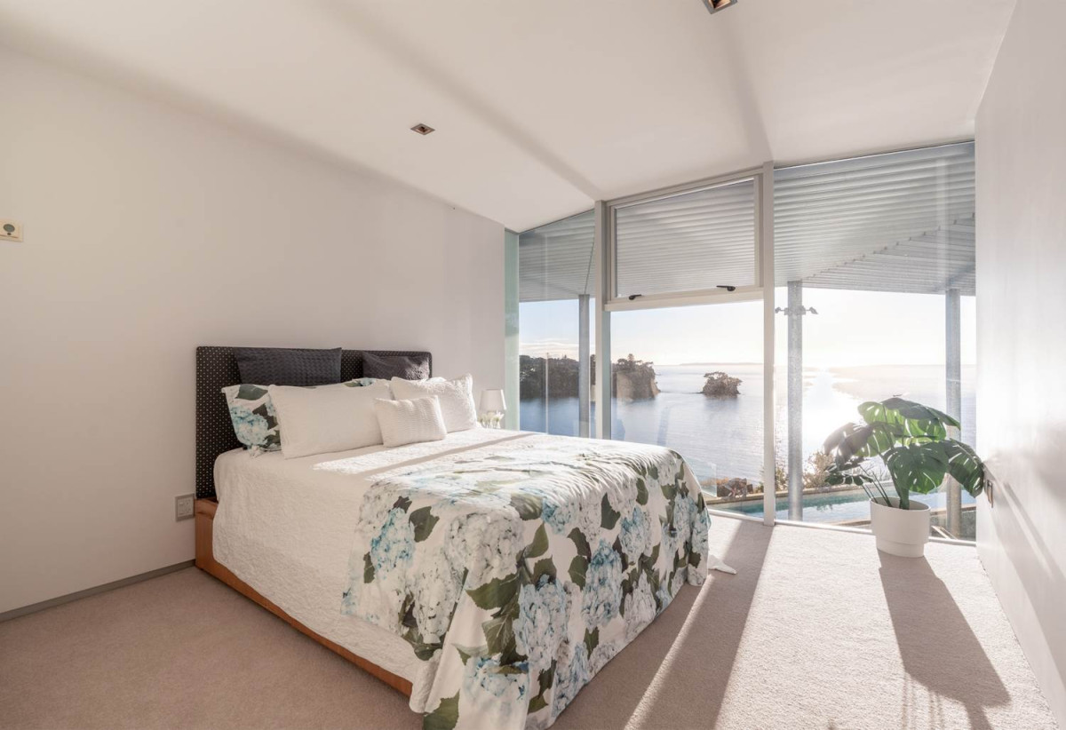 Just 160 metres from Waiake Beach, 1948m2 section, Built-in lift, 5 beds (5 ensuites) + office and wine room 6.5 baths house with 4 garage and the 18-metre cantilevered lap pool, 4 Sharon Road, Waiake, Auckland