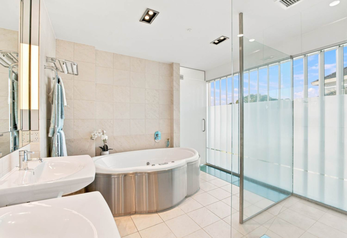 Just 160 metres from Waiake Beach, 1948m2 section, Built-in lift, 5 beds (5 ensuites) + office and wine room 6.5 baths house with 4 garage and the 18-metre cantilevered lap pool, 4 Sharon Road, Waiake, Auckland